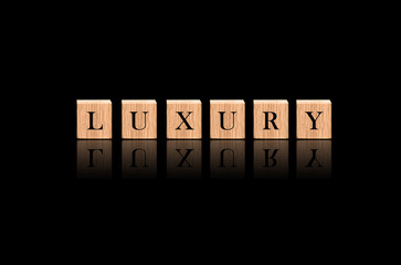 The Word "Luxury" in Black Luxuries Background. Made by Wooden Blocks 