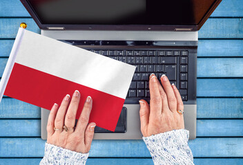 woman hands and flag of Poland on computer, laptop keyboard 