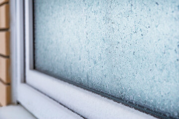 Frozen glass window.Selective soft focus.Concept of textured background,cold winter weather,frost.