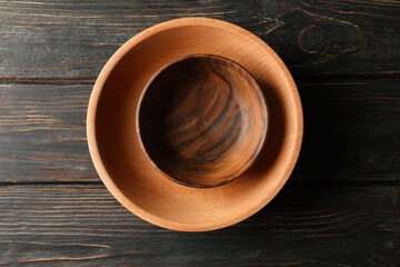 Empty wooden bowls on wooden table, top view