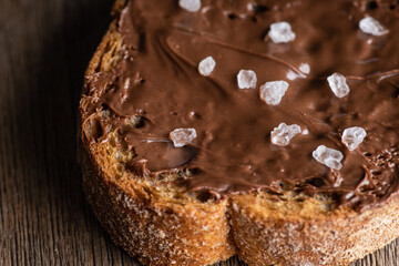 Slice of homemade bread with chocolate cream on the kitchen table for breakfast. Selective focus. Shallow depth of field. 
