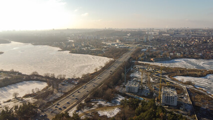 Frozen city road. Winter aerial cityscape of town with road. Splendid morning view from dron.