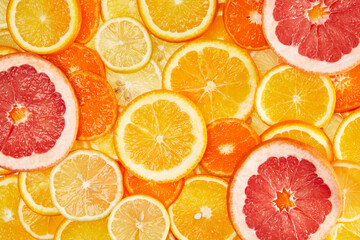 Colorful creative background of orange, lemon, grapefruit and Mandarin slices. Flat lay macro close-up, top view
