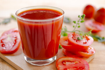 Tomato juice in glass with row tomato on wood background. fresh organic vegetables. healthy juice drinks concept.