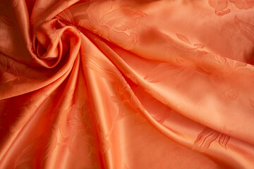 Orange fabric or luxury silk satin for background.