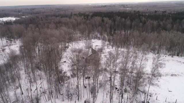 Flying over a lonely house in a snowy forest. Aerial photography