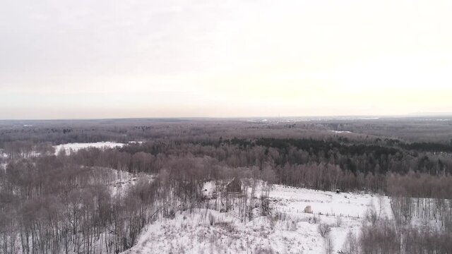 Flying over a lonely house in a snowy forest. Aerial photography