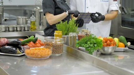 Restaurant chef makes a verification in kitchen. Interacting to head chef in commercial kitchen