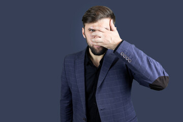 a bearded man in a blue suit covered his eyes with h