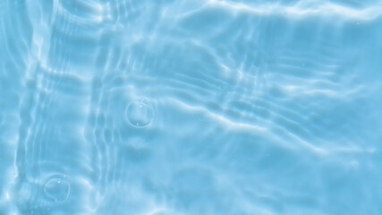 Fototapeta na wymiar Photo of water waves shadow on pool bottom. Subtle texture of light-shadow pattern of sunlight reflection from rippled water surface with bubbles. Beautiful natural wallpaper of blue water ripples.