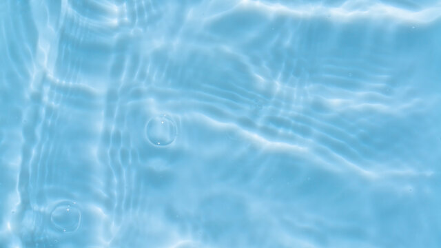 Photo of water waves shadow on pool bottom. Subtle texture of light-shadow pattern of sunlight reflection from rippled water surface with bubbles. Beautiful natural wallpaper of blue water ripples.