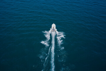 Aerial bird's eye view photo taken by drone of boat. Top view of a white boat sailing to the blue...