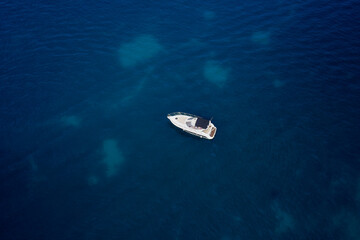 White, large yacht, mooring on blue water, aerial view of the yacht