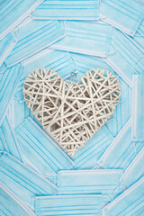 White heart on a background of a blue faces masks. Concept of a Valentines day during Coronavirus or Covid pandemic.
