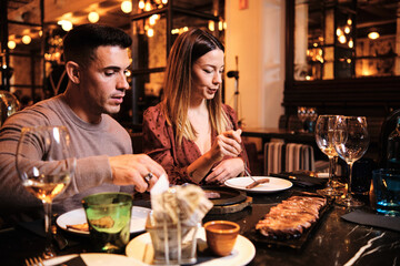 Young couple having dinner together at restaurant.