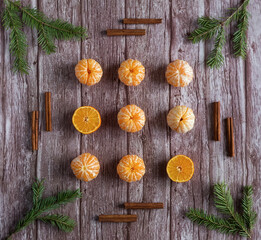 Orange tangerine branches Christmas tree cinnamon sticks on wooden background