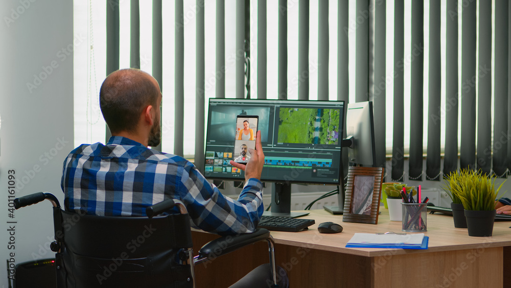 Aufkleber handicapped videographer in wheelchair talking on webcam with cowerkers while editing a video projec