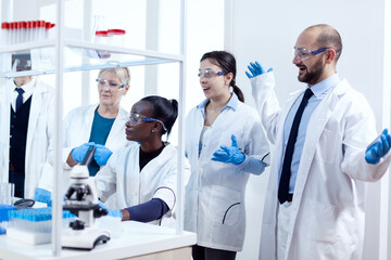 Group of scientists with diverse race working to find a cure vor virus during pandemic. Black...