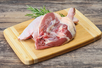 Raw duck leg served rosemary