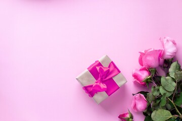 present tied with pink ribbon and pink roses bouquet. valentine's day, christmas, mother's day, birthday presents. Greeting card concept