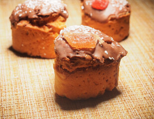 Three handmade cupcakes. Homemade cupcakes are decorated with chocolate icing, coconut chips, and marmalade.
