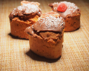 Three handmade cupcakes. Homemade cupcakes are decorated with chocolate icing, coconut chips, and marmalade.