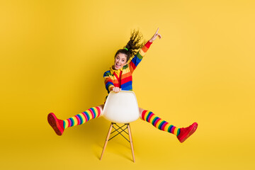 Full size photo of crazy girl sit fast ride chair point finger up copyspace isolated on bright color background