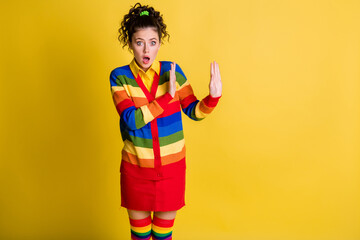 Photo of shocked frightened lady raise arms express refuse wear striped sweater skirt knee socks isolated yellow color background