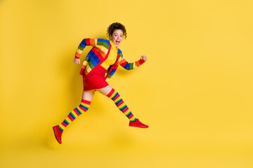 Full length body size profile side view of glad cheerful wavy-haired girl jumping running isolated bright yellow color background