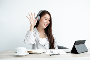 Video Calling a young Asian woman wearing headphones communicates via online long-distance video on...