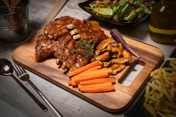 Grilled sliced barbecue pork ribs on wooden plate. Delicious Pork Spare Ribs BBQ seasoned with a...