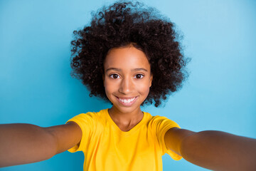 Photo of charming pretty little dark skin girl make selfie blogger isolated on pastel blue color...
