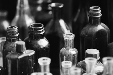 Many Old Deutsch Vintage Medical Glass Capacity. Detail Of Retro Chemical Pharmaceutical Science Researches. Small Bottles Different Sizes From Times Of World War II. WW2 WWII. Black And White