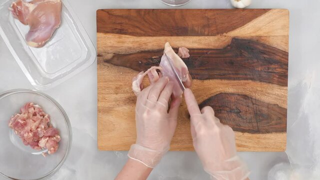 Fresh raw chicken fillet  on wooden cutting board. Chef chopping meat, close up video from above. Sour cream chicken paprika step by step recipe.