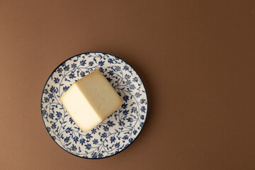 wedge of Spanish cheese on brown background