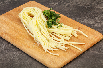 Chechil spaghetti cheese over board
