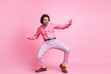Fototapeta na wymiar Full length photo of cheerful funny brunet hair guy dancing hands arms sides isolated pink color background