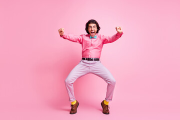 Full length photo of funky handsome brunet hair guy dancing imagining himself bike isolated pink color background