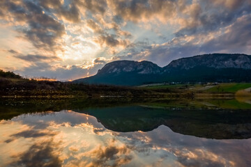 beautiful reflection in a pond with mountains during sunset