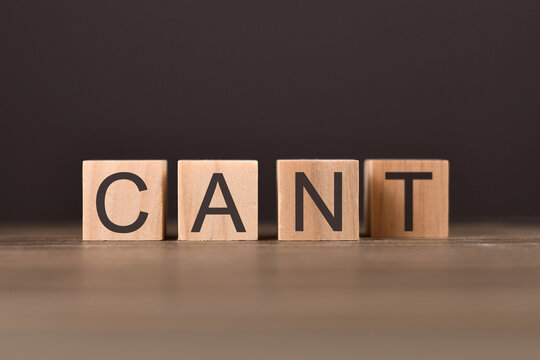 Concept for success and challanges with wooden cubes spelling  word 'CAN'T'  with letter T in back