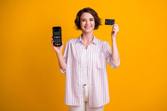 Photo of positive cheerful girl hold credit card machine reader enjoy paying purchase online banking wear style white outfit isolated over bright shine color background