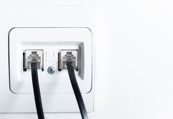 Naklejka premium telephone socket and telephone cable on the wall