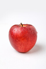 Water drop on fresh red apple on white background