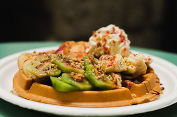 Tasty waffle with kiwis on top of it