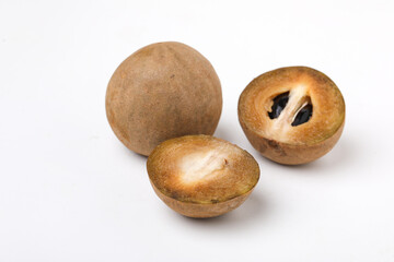 fresh whole and half of sapodilla fruit isolated on white background