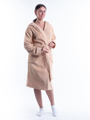 woman in a Bathrobe on an isolated white background with a smile on her face. Shot in the Studio in full growth.