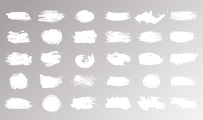 Large set of strokes, brushes, lines, roughness of white color isolated on beige background. Modern textured shapes. Straight brush strokes. Vector illustration.