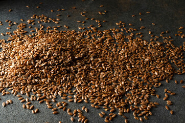 Obraz premium Closeup of heap of dried raw flaxseeds on the dark grey surface