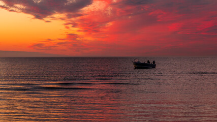 Beautiful sunset. pink, purple, golden, orange, blue colors over the sea. sky full of many colors. Boat in the water