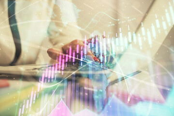 Double exposure of businesswoman hands typing on computer and financial graph hologram drawing. Stock market analysis concept.